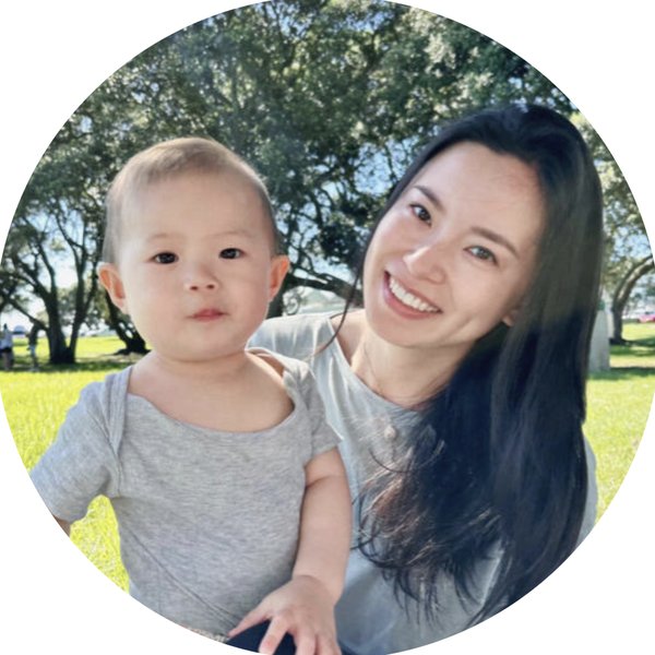Keqing Gan, founder of LingNest, smiling outdoors with her young child